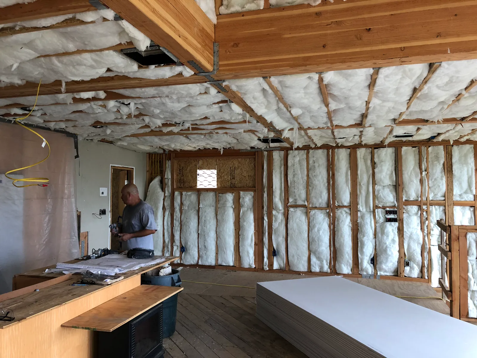 An open hillside interior in framing and insulation, board stacked ready.