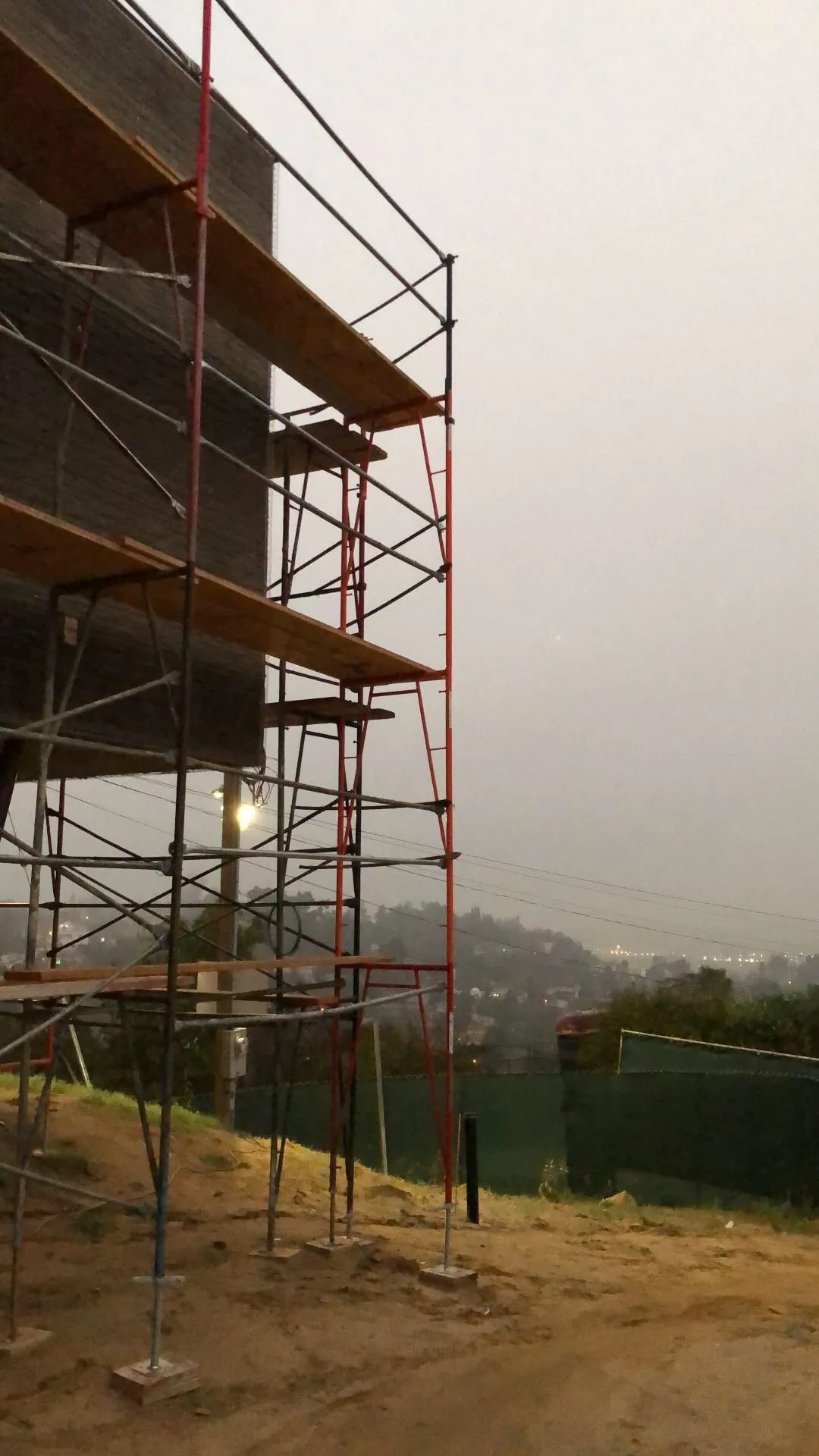 Scaffolding against the exterior wall of the hillside house.